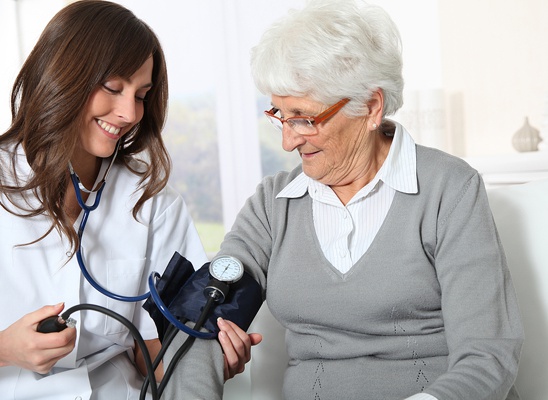 Médica tomando la presión arterial a una adulta mayor